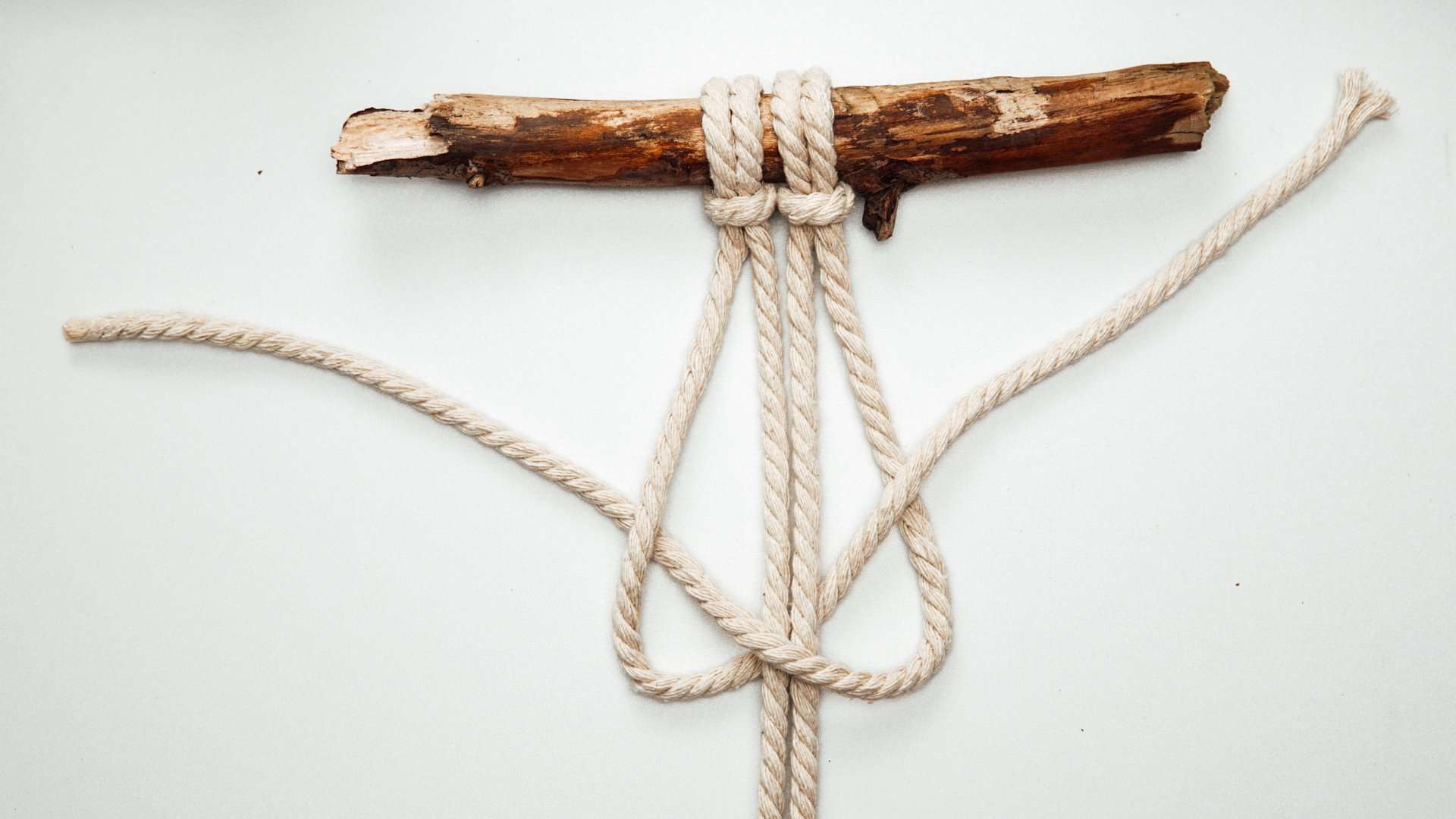 Kreuzknoten von rechts Arbeitsfaden zusammenlegen auf einem Tisch